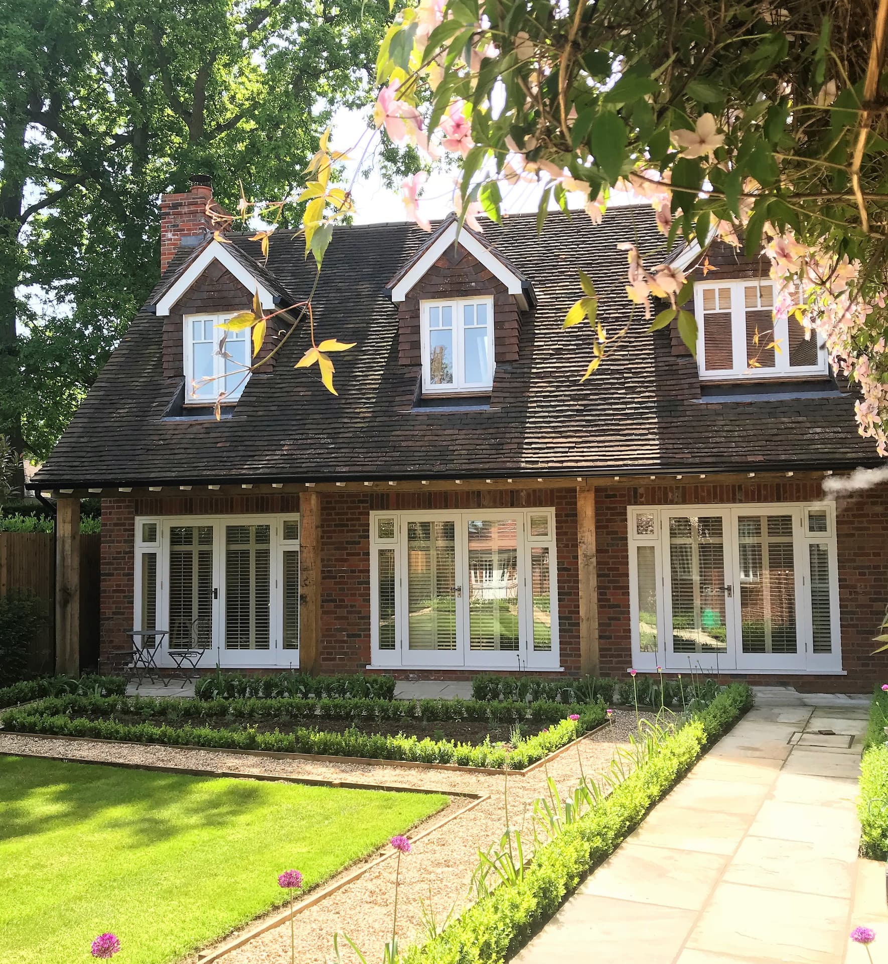 A beautifully renovated and extended family home with dormer windows and a manicured garden