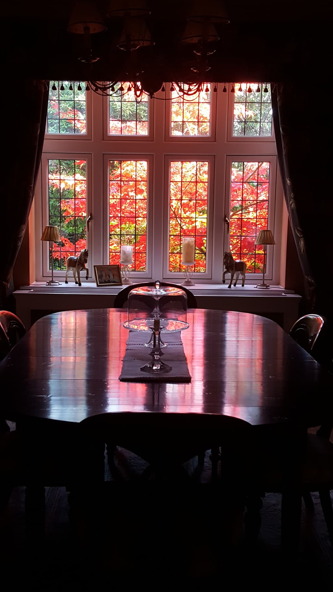 A characterful dining room framed by a stained-glass bay window